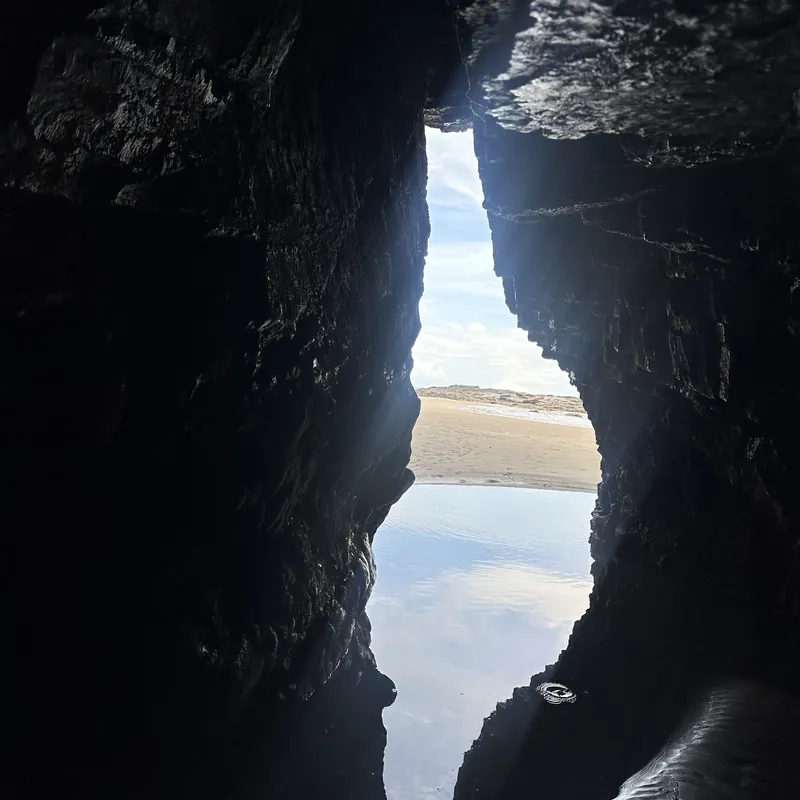 A sea cave opening onto a quiet beach