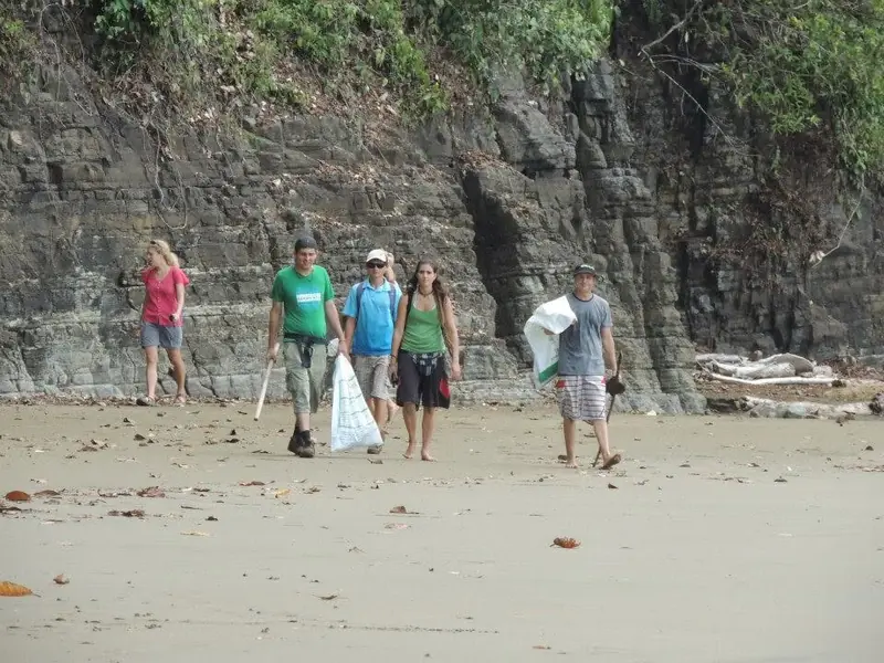 Volunteers collecting trash during a beach cleanup at Playa Arco