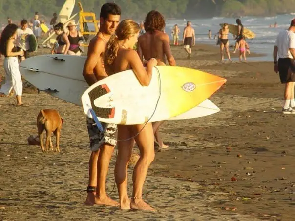 Surfers with their boards on Playa Dominical at sunset