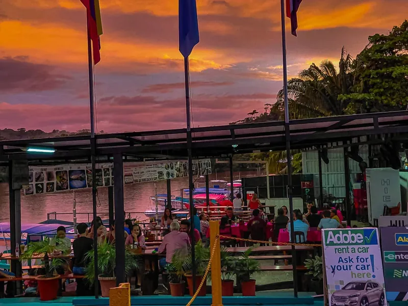 Terraza del restaurante a orillas del río al atardecer en Sierpe